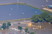 Completed wellpad: Wellhead, crude oil tanks, toxic waste water tanks, separators, combustor flares submerged under flood waters