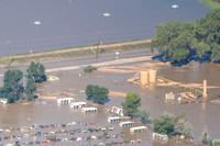 Completed wellpad: Wellhead, crude oil tanks, toxic waste water tanks, separators, combustor flares submerged under flood waters